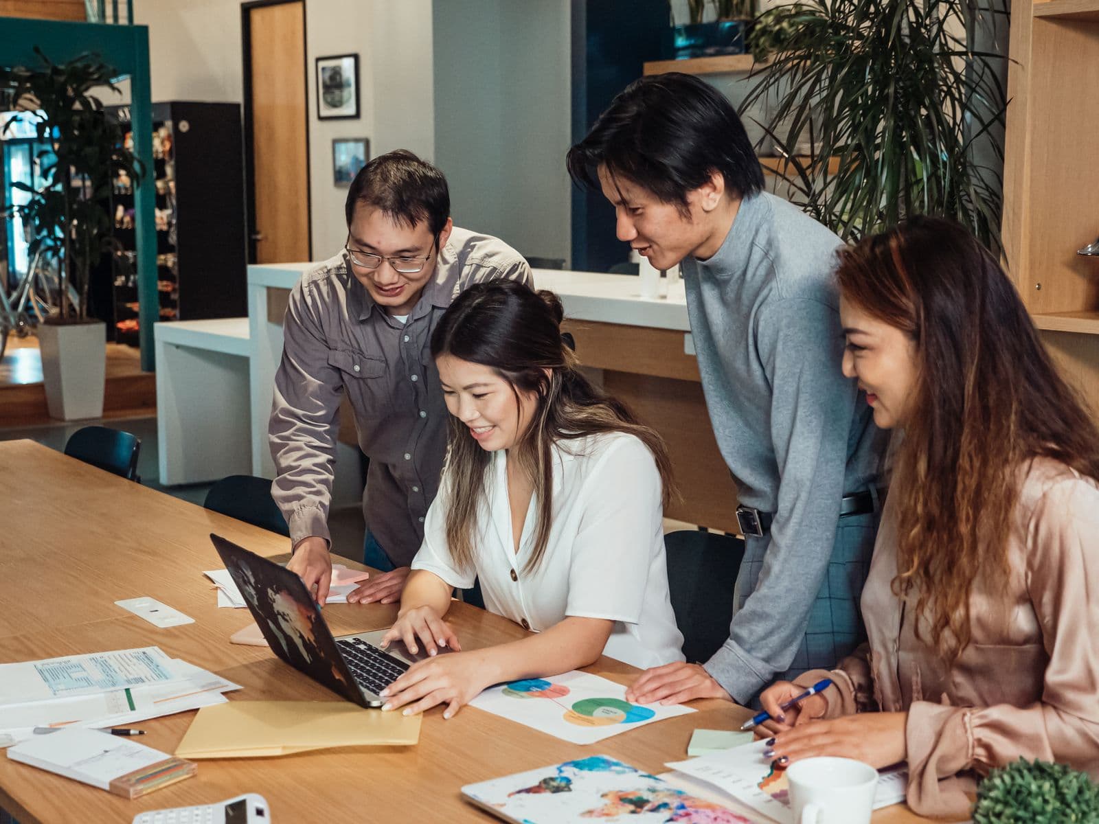 Marketingteam werkt samen rond een scherm met ontwerpwerk in een creatieve studio